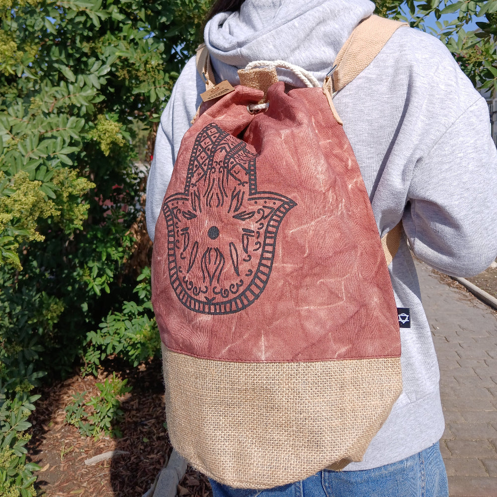 Person wearing a drawstring bag with a design outdoors