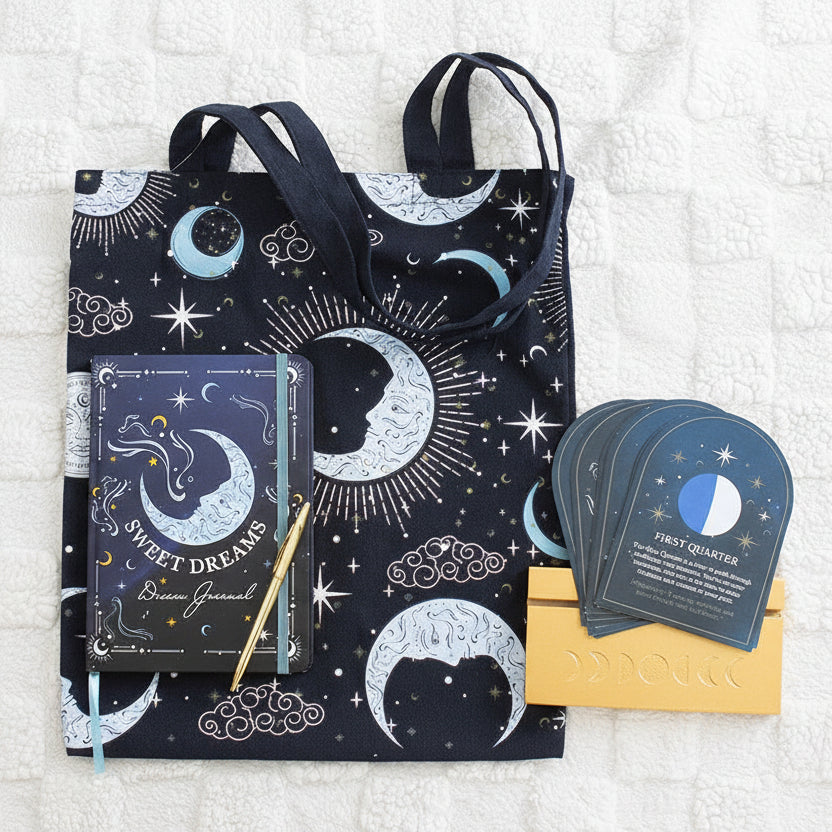  celestial-themed products including a tote bag, notebook, and cards on a textured surface