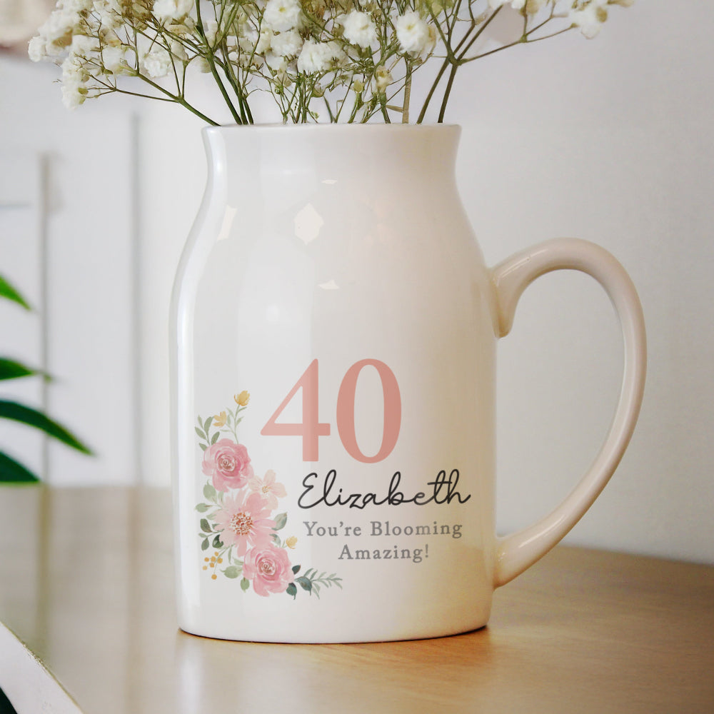 White vase with floral design and text on a wooden surface