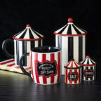 Set of ceramic canisters with striped design and text on a dark background