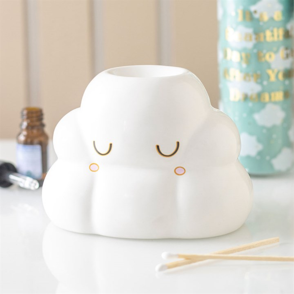 White cloud-shaped diffuser with a face on a surface with a blurred background