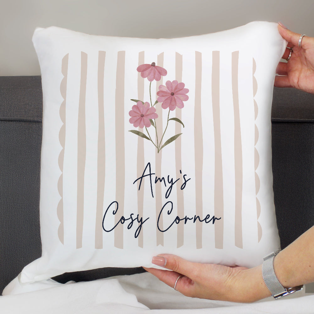 White pillow with pink flowers and 'Amy's Cosy Corner' text held by a person.