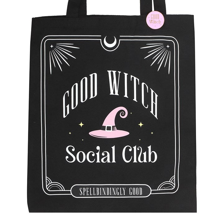 Black tote bag with 'Good Witch Social Club' text and pink witch hat design on a white background