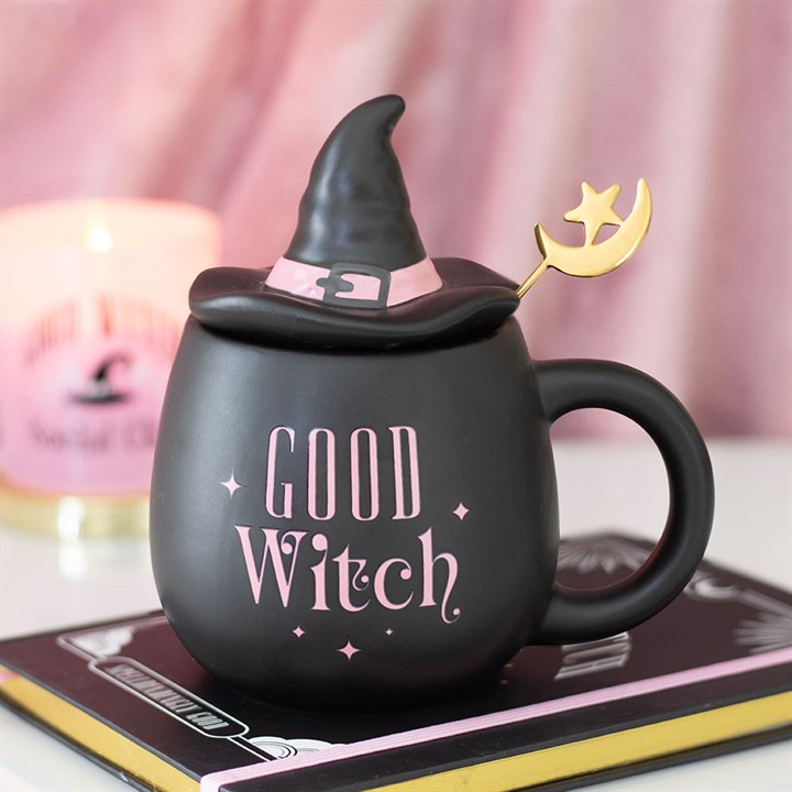 Black mug with 'Good Witch' text  in pink and witch hat on top, on a pink background