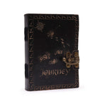 Black leather-bound journal with 'Journey' text and decorative elements on a white background