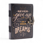 Black notebook with 'Never give up on your dreams' text on a white background