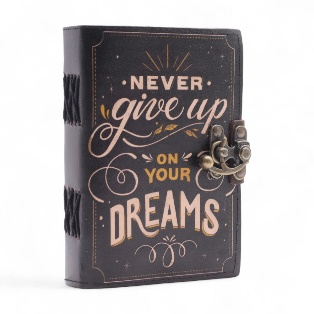 Black notebook with 'Never give up on your dreams' text on a white background