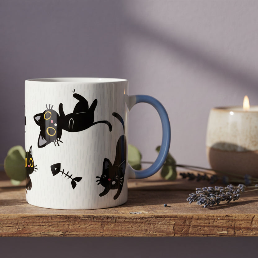 White mug with black cat illustrations and a blue handle on a white background