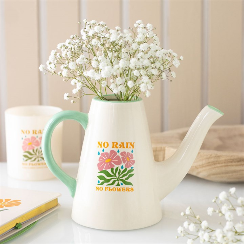 White ceramic watering can with floral design and 'No Rain No Flowers' text, filled with baby's breath flowers.