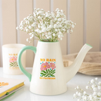White ceramic watering can with floral design and 'No Rain No Flowers' text, filled with baby's breath flowers.