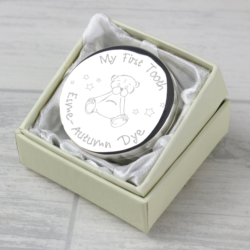 Round silver coin with engraved text and bear design in a box on a light gray surface