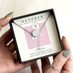 Necklace in a gift box with a personalized message card held by a hand.