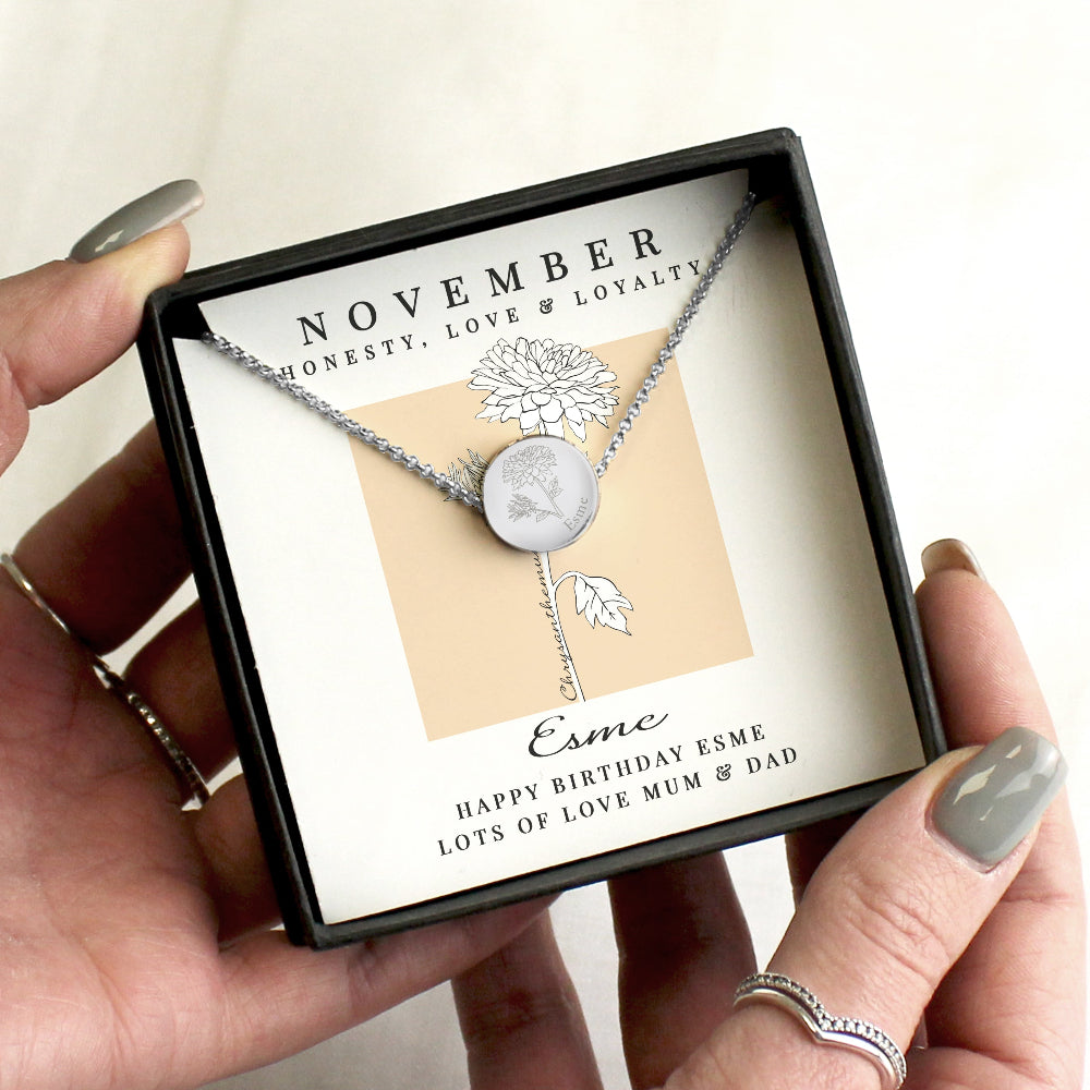 Necklace with engraved design held in a box with 'November' and 'Esme' text.