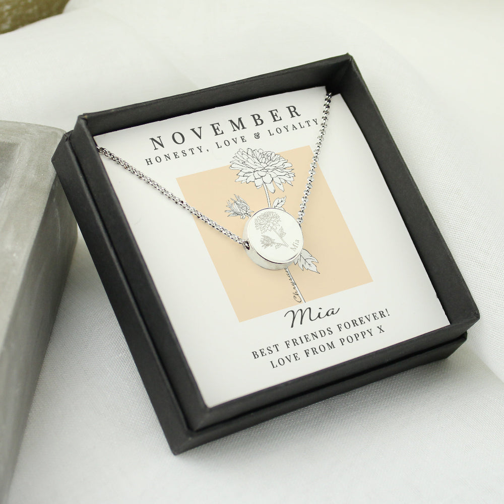 Silver necklace in a black box with a personalized message card on a light background
