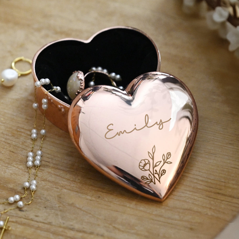 Rose gold heart-shaped jewelry box with 'Emily' engraving on a wooden surface