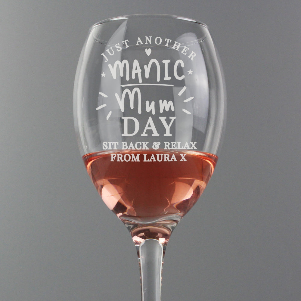 Wine glass with engraved text on a gray background