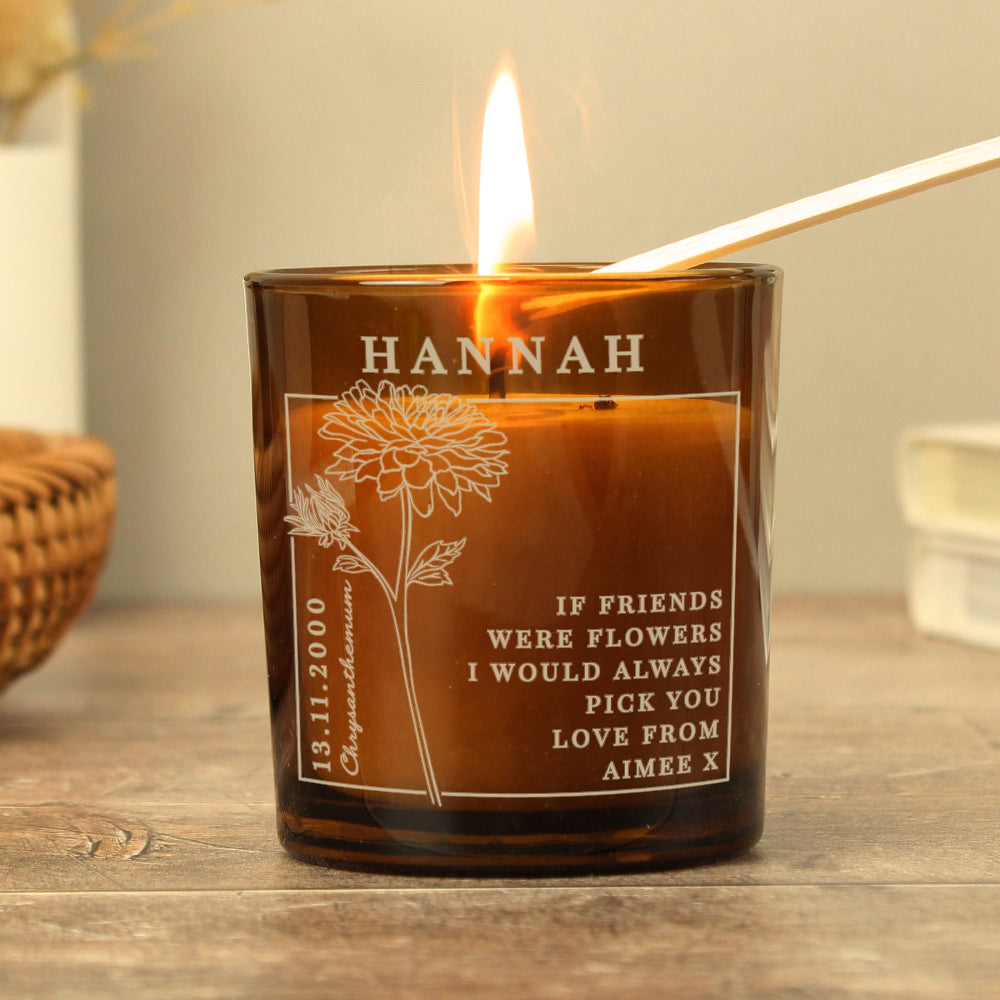Personalized candle with engraved text and floral design on a wooden surface