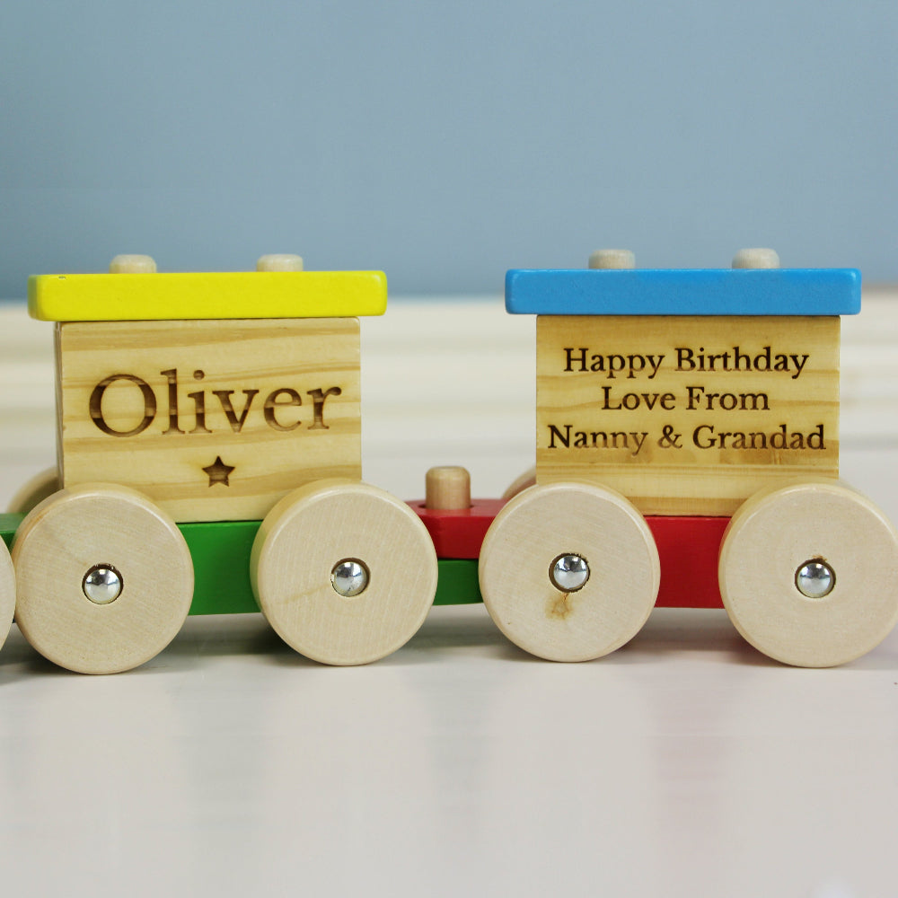 Wooden toy train with personalized messages on a light background