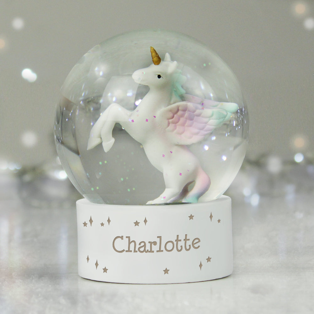 Unicorn figurine inside a snow globe with 'Charlotte' on a stand