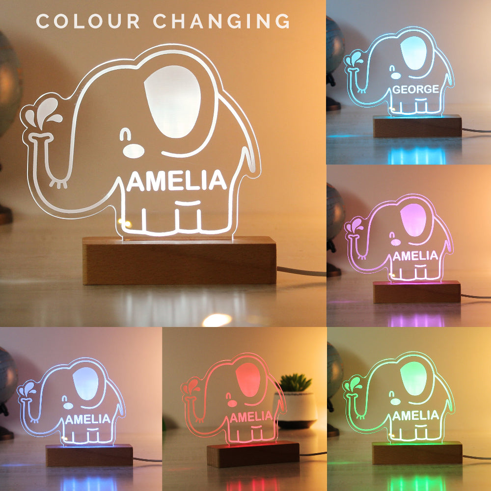 Color-changing elephant-shaped LED lamp with 'Amelia' and 'George' names on a wooden base.