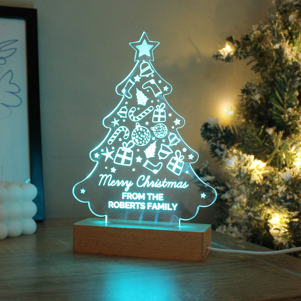 Decorative Christmas tree light with 'Merry Christmas from the Roberts Family' text, placed on a surface with a blurred background.