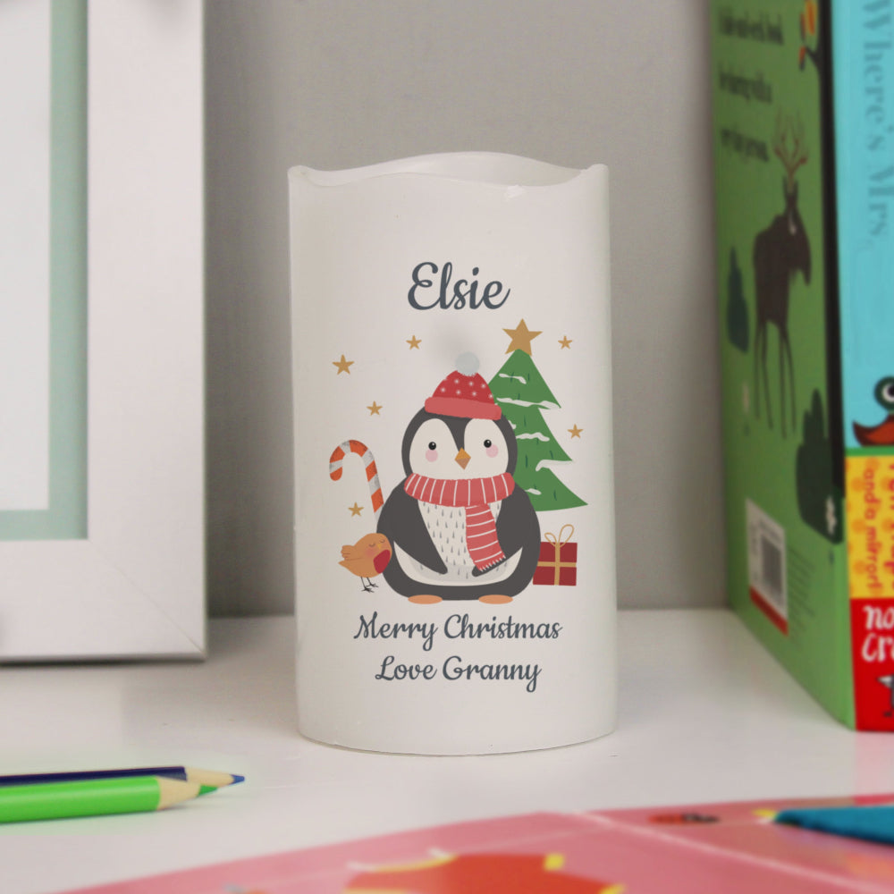 White LED candle with a Christmas design featuring a penguin, tree, and candy cane, personalized with 'Elsie, Merry Christmas Love Granny'.