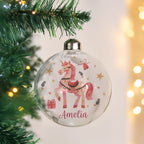 Decorative Christmas ornament with a unicorn design and the name 'Amelia' on a tree.