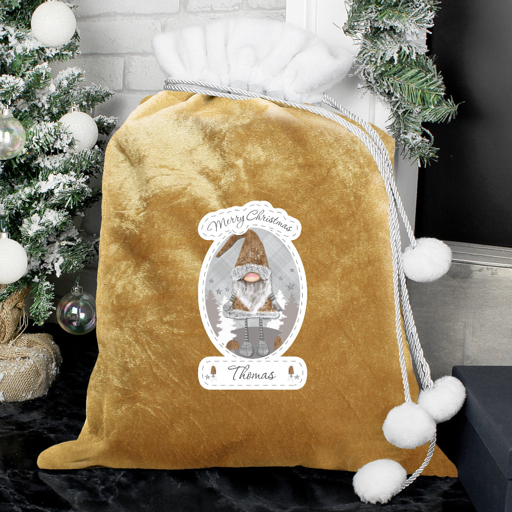Gold velvet drawstring bag with Christmas-themed design and tree in the background