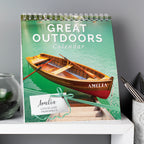 Calendar titled 'Great Outdoors' with a boat design on a gray surface