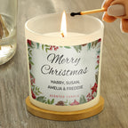 Candle being lit with a 'Merry Christmas' label on a wooden surface
