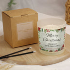 Vanilla scented candle with 'Merry Christmas' label next to a cardboard box on a wooden surface.