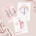 Three milestone cards for Hattie with numbers and birthday-themed designs on a light pink background.