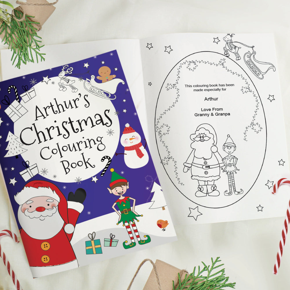 Christmas-themed coloring book with Santa Claus and elves on a white surface.