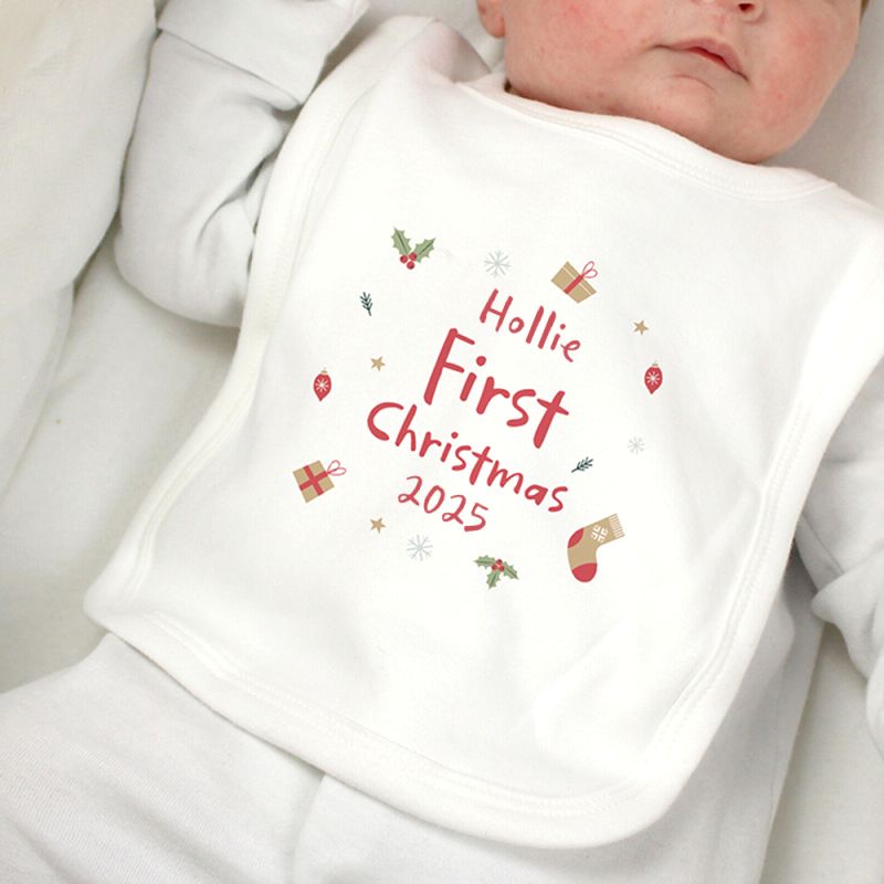 Baby wearing a 'Hollie First Christmas 2025' bib
