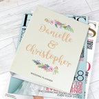 Wedding planner with personalized names on a magazine stack