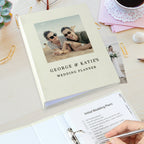 Wedding planner book with a photo of a couple on the cover, placed on a desk with stationery items.