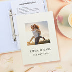 Personalized photo album with 'Emma & Karl 1st May 2024' on a desk with stationery items.