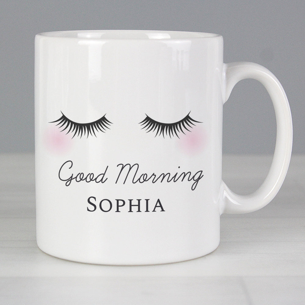 White mug with eyelash design and 'Good Morning Sophia' text on a gray background