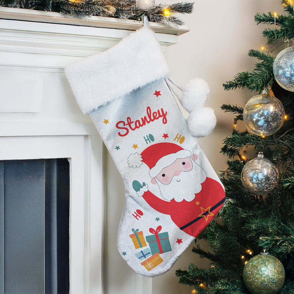 Christmas stocking with 'Stanley' on a fireplace mantle next to a decorated tree.