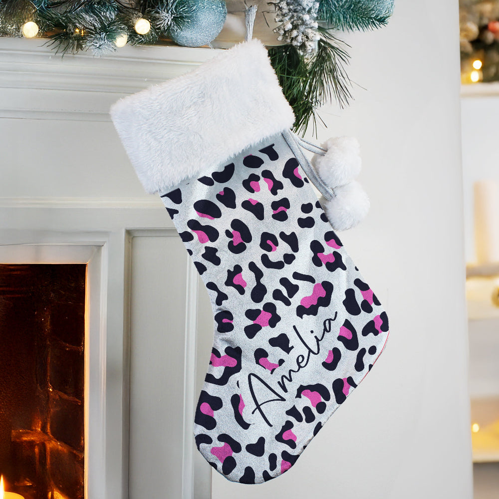 Leopard print Christmas stocking with 'Amelia' on a fireplace mantle.