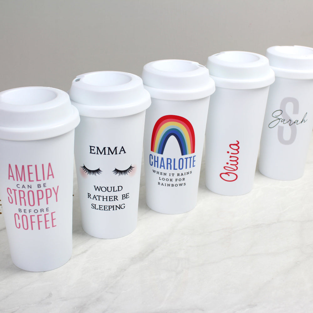 Set of personalized white tumblers with various designs and names on a light background