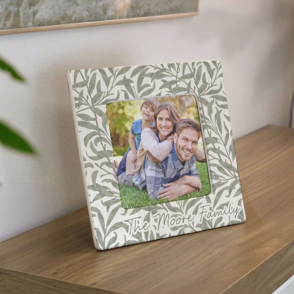 Decorative photo frame with a family photo and 'The Moore Family' text on a wooden surface.