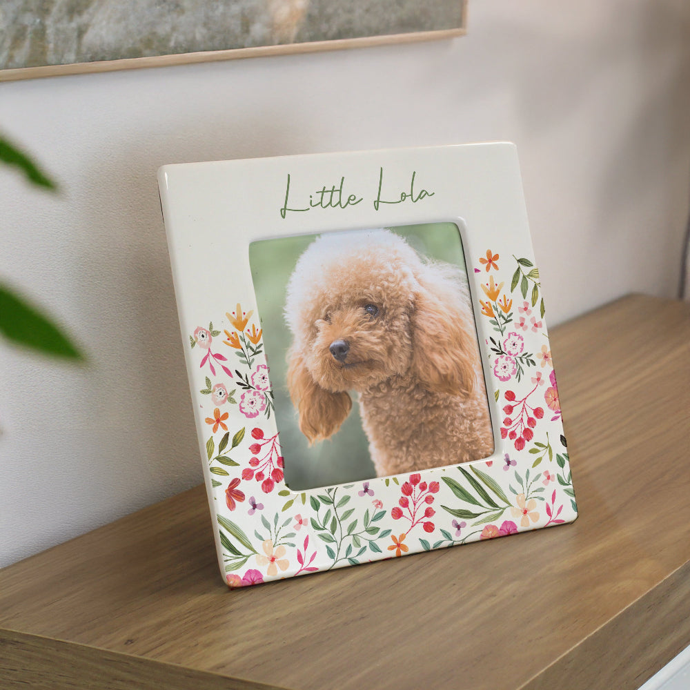 Floral photo frame with a dog picture on a wooden surface