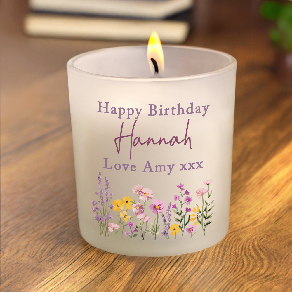 Personalized birthday candle with floral design and text on a wooden surface