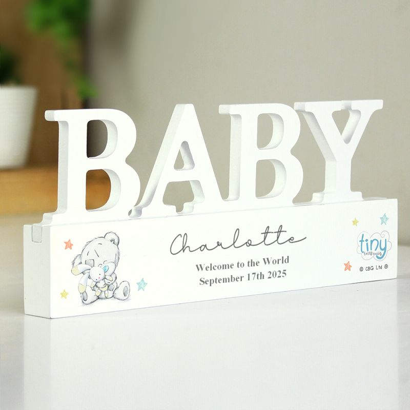 Decorative sign with 'BABY' and personalized text on a white surface