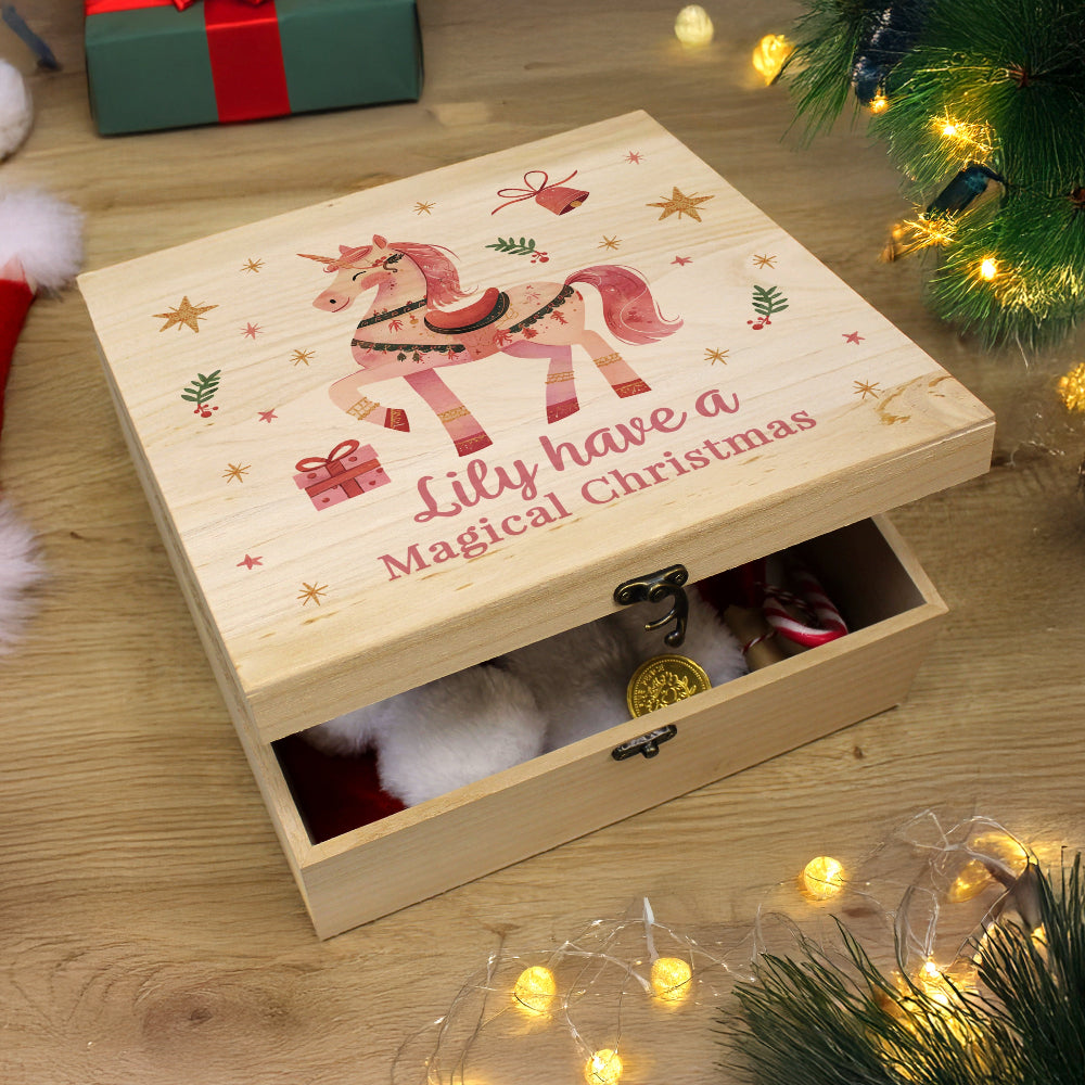 Wooden Christmas box with unicorn design and text 'Lily have a Magical Christmas' on a wooden surface with festive decorations.