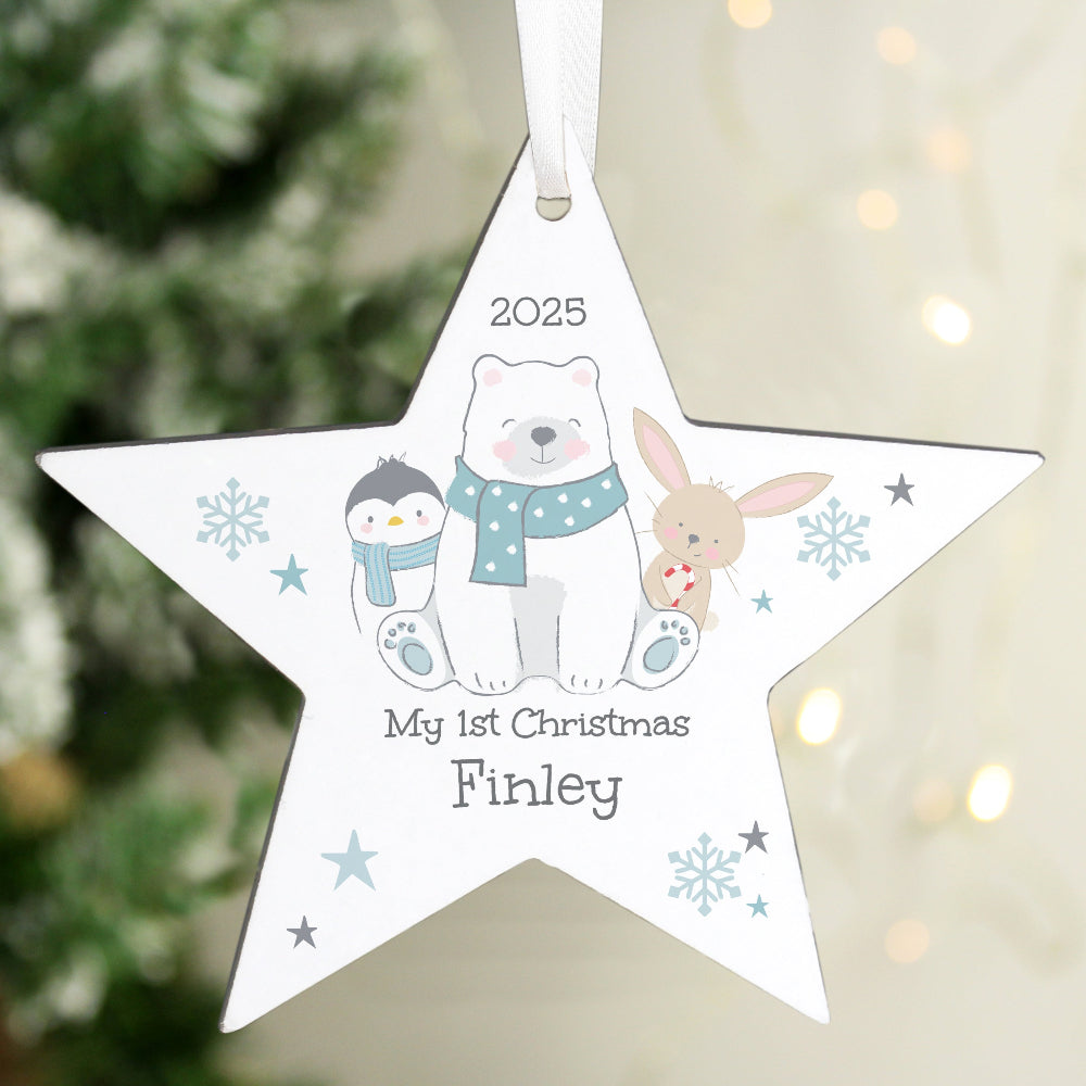 Star-shaped Christmas ornament with cartoon characters and text, hanging against a blurred Christmas tree background.