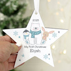 Star-shaped Christmas ornament with cartoon characters and text, held by a hand with a blurred Christmas tree in the background.