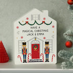 Decorative house-shaped sign with Christmas-themed design and personalized text on a gray background.