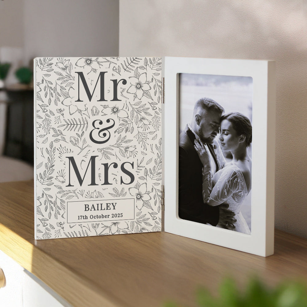 Personalized photo album with 'Mr & Mrs' design on a wooden shelf.